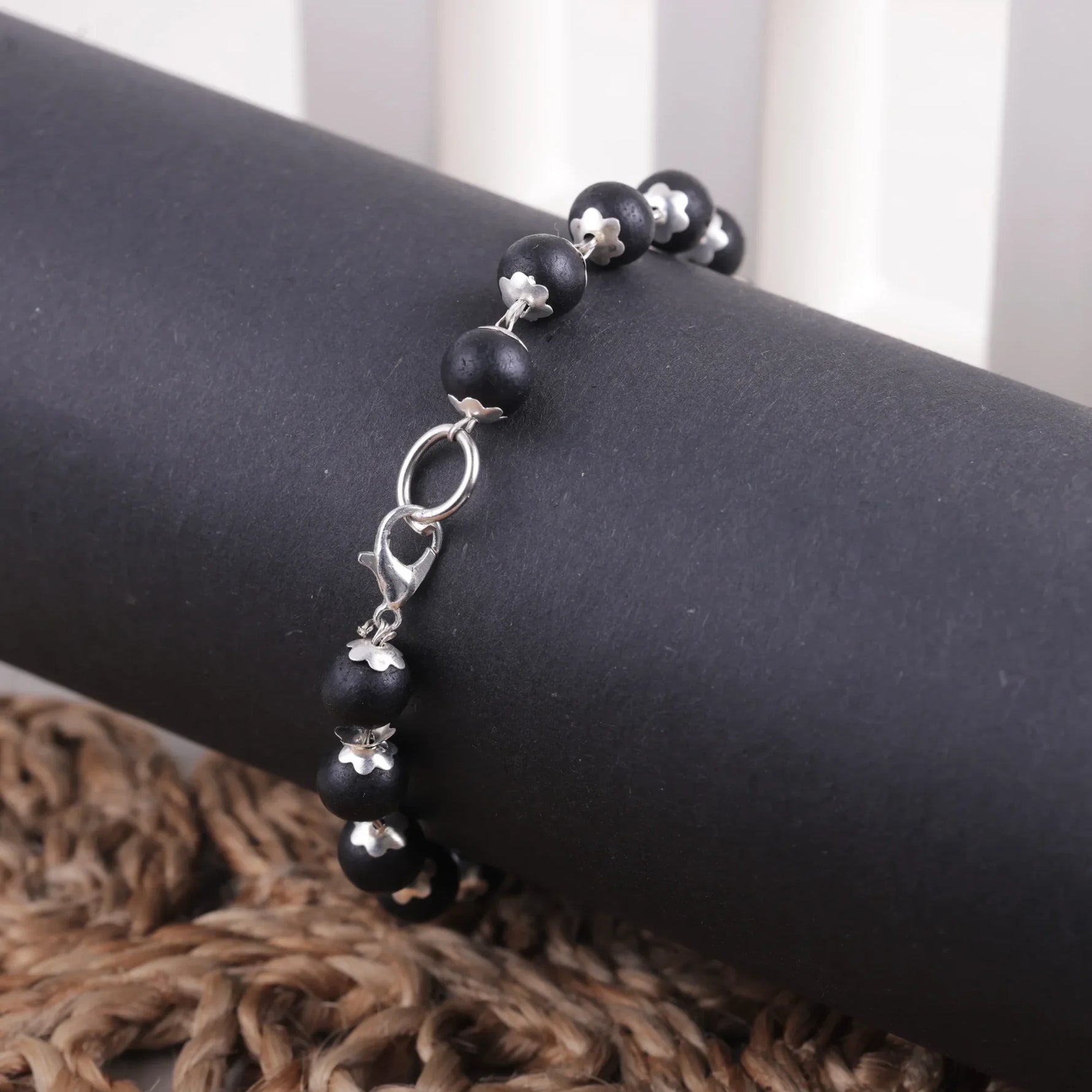 Close-up of Karungali ebony wood bracelet showing silver caps and lobster clasp