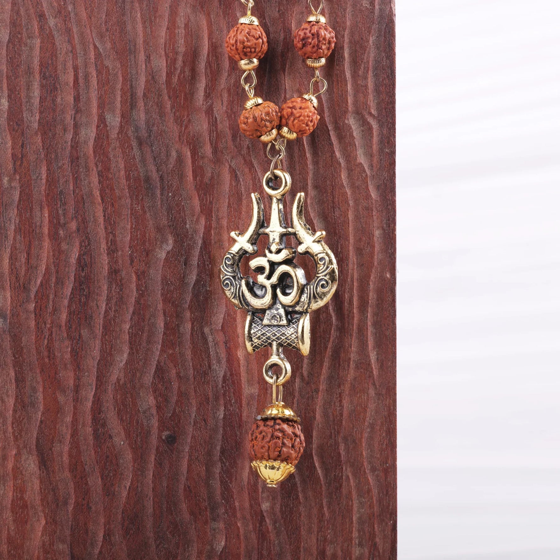 Close-up of OM Trishool gold pendant with Rudraksha beads