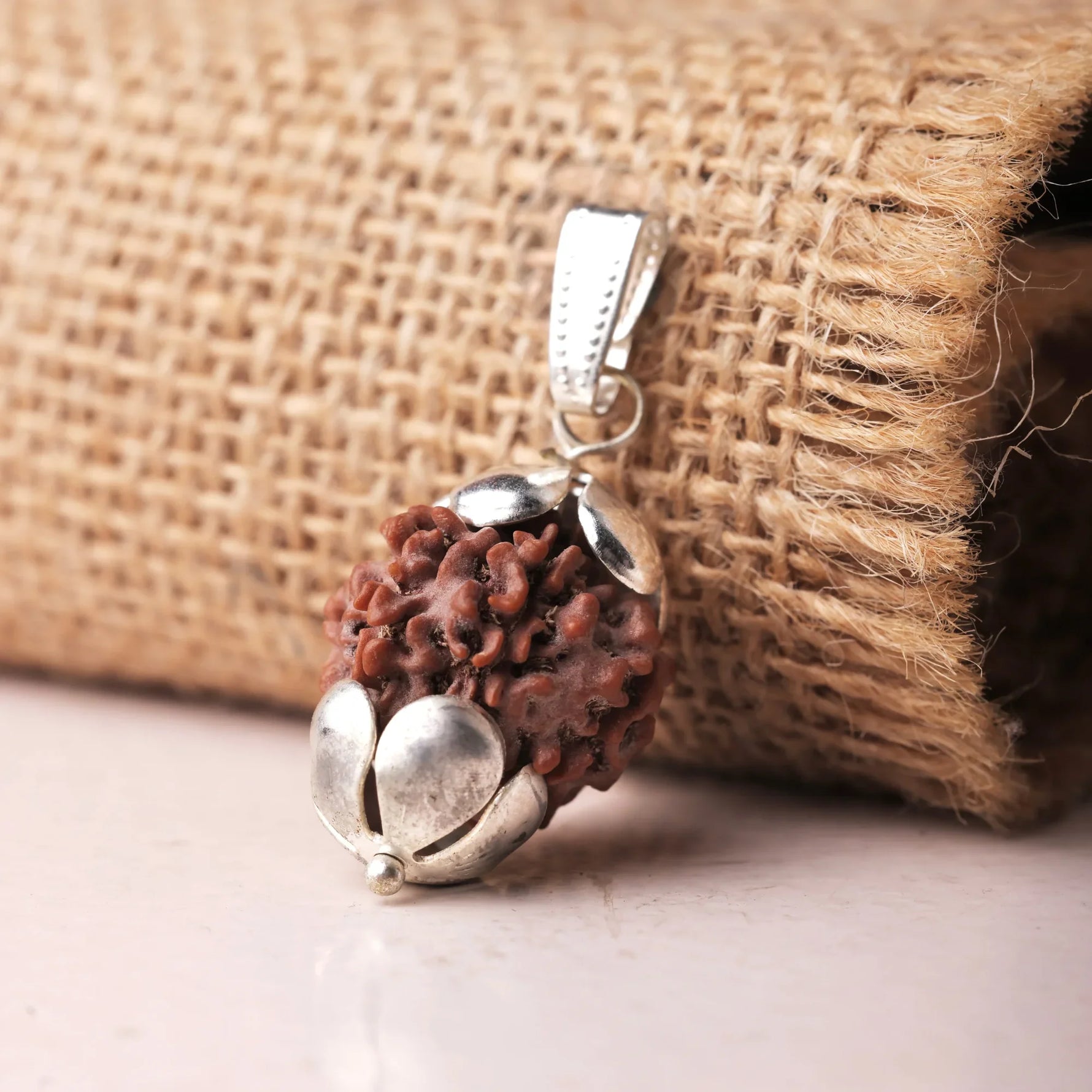 Close-up of authentic 7 Mukhi Rudraksha pendant showing handcrafted ornate silver cap detail