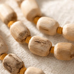 Close-up of natural Tulsi wood beads showing hand-knotted texture