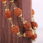 Close-up of natural 5 Mukhi Rudraksha beads with gold-tone cap detail