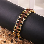 Gold plated Rudraksha chain bracelet on black jewelry stand