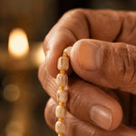 Hand holding Tulsi mala beads during meditation and mantra chanting