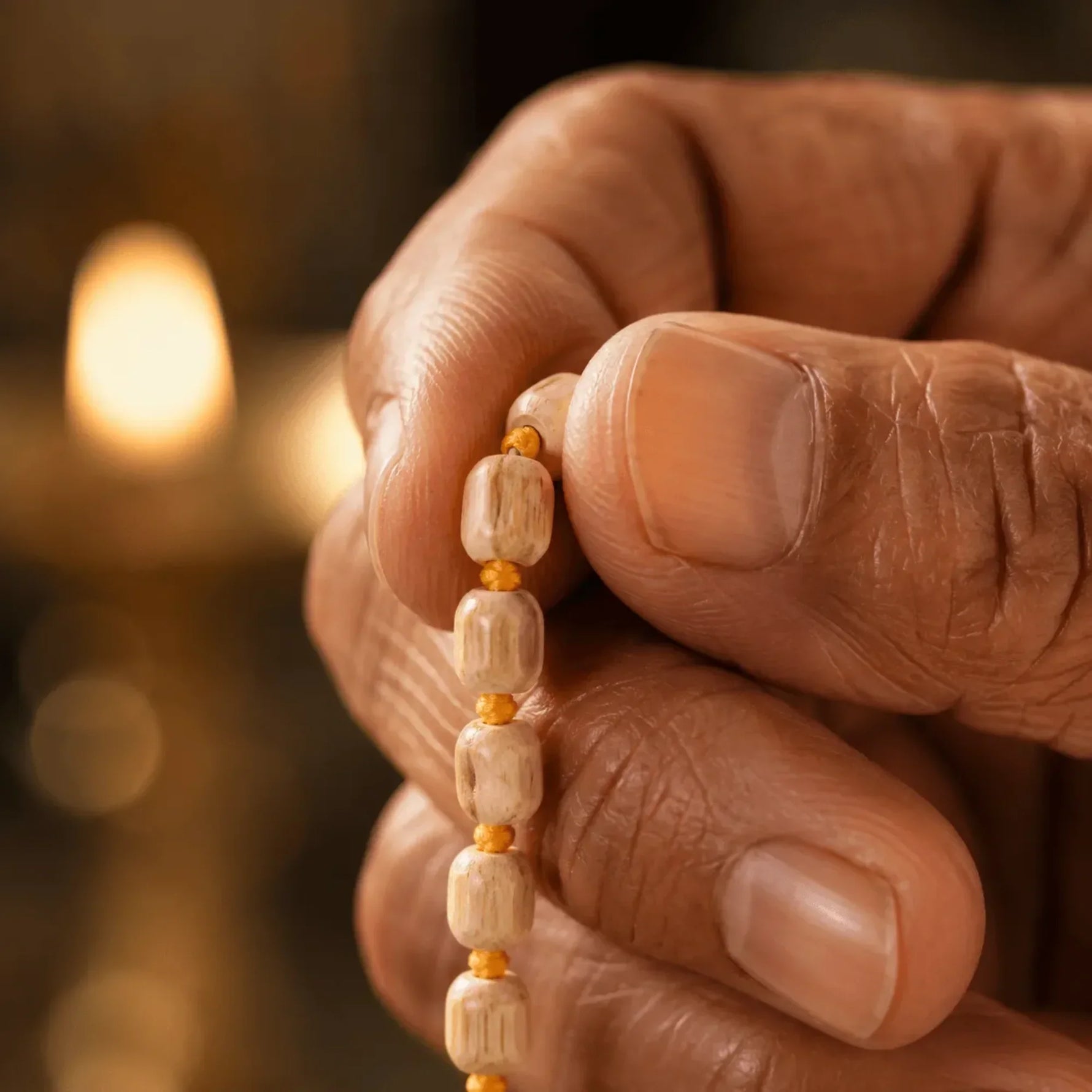 Hand holding Tulsi mala beads during meditation and mantra chanting