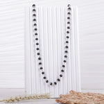 Original Karungali Malai on white display stand, natural ebony wood beads