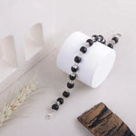 Handmade Karungali bracelet on white jewelry stand with natural decor