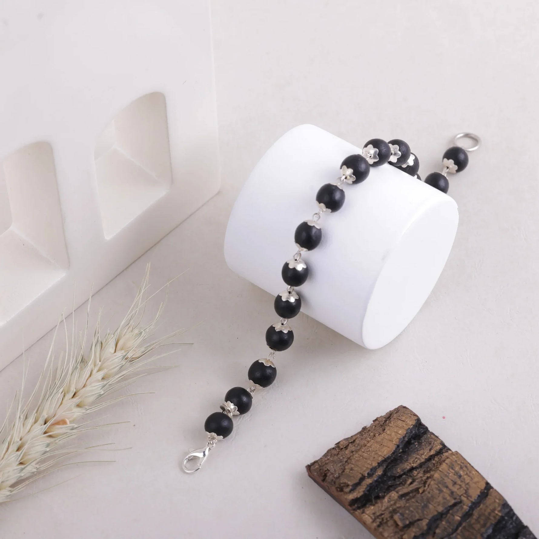 Handmade Karungali bracelet on white jewelry stand with natural decor