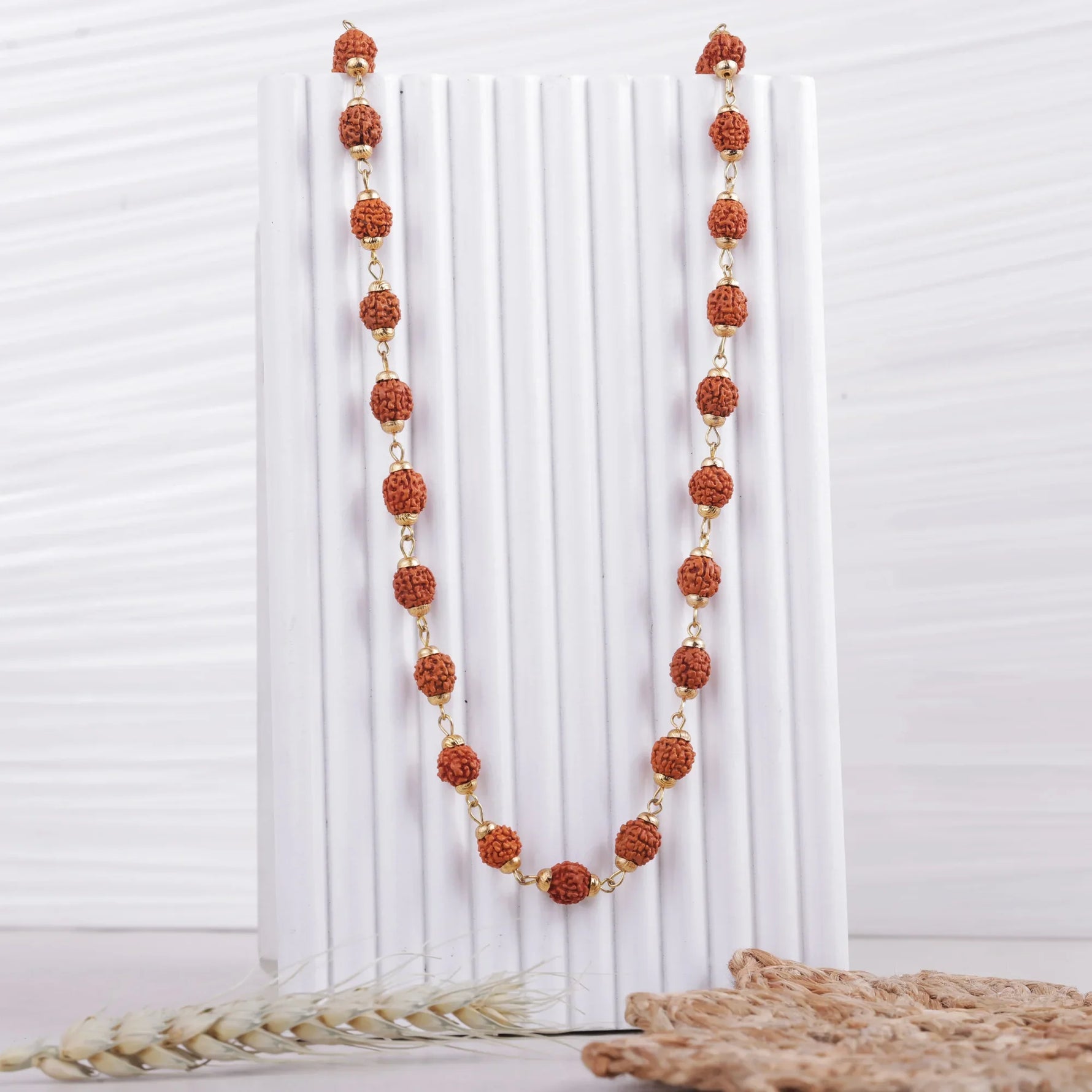 5 Mukhi Rudraksha mala displayed on white stand, Divymukhi