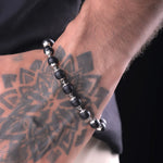 Karungali ebony wood bracelet worn on tattooed wrist, natural black beads