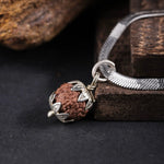 Indonesian Rudraksha pendant with silver floral cap, macro detail shot