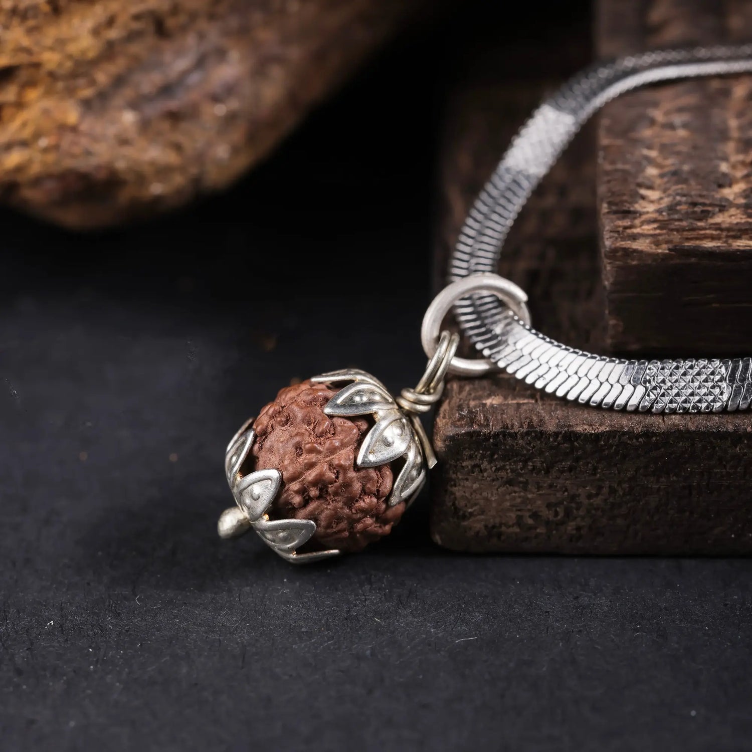 Indonesian Rudraksha pendant with silver floral cap, macro detail shot
