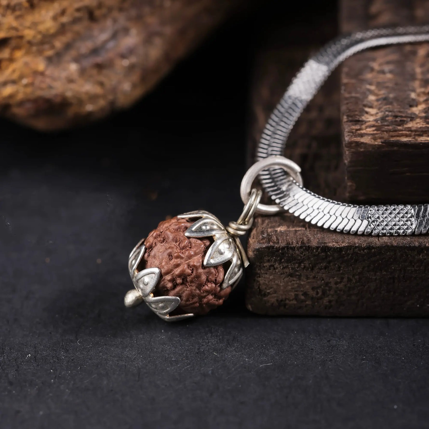 Indonesian Rudraksha pendant with silver floral cap, macro detail shot