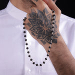Man holding Karungali Malai ebony wood necklace with silver links