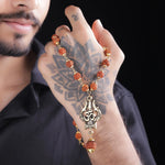 Man holding OM Trishool Rudraksha necklace with gold pendant