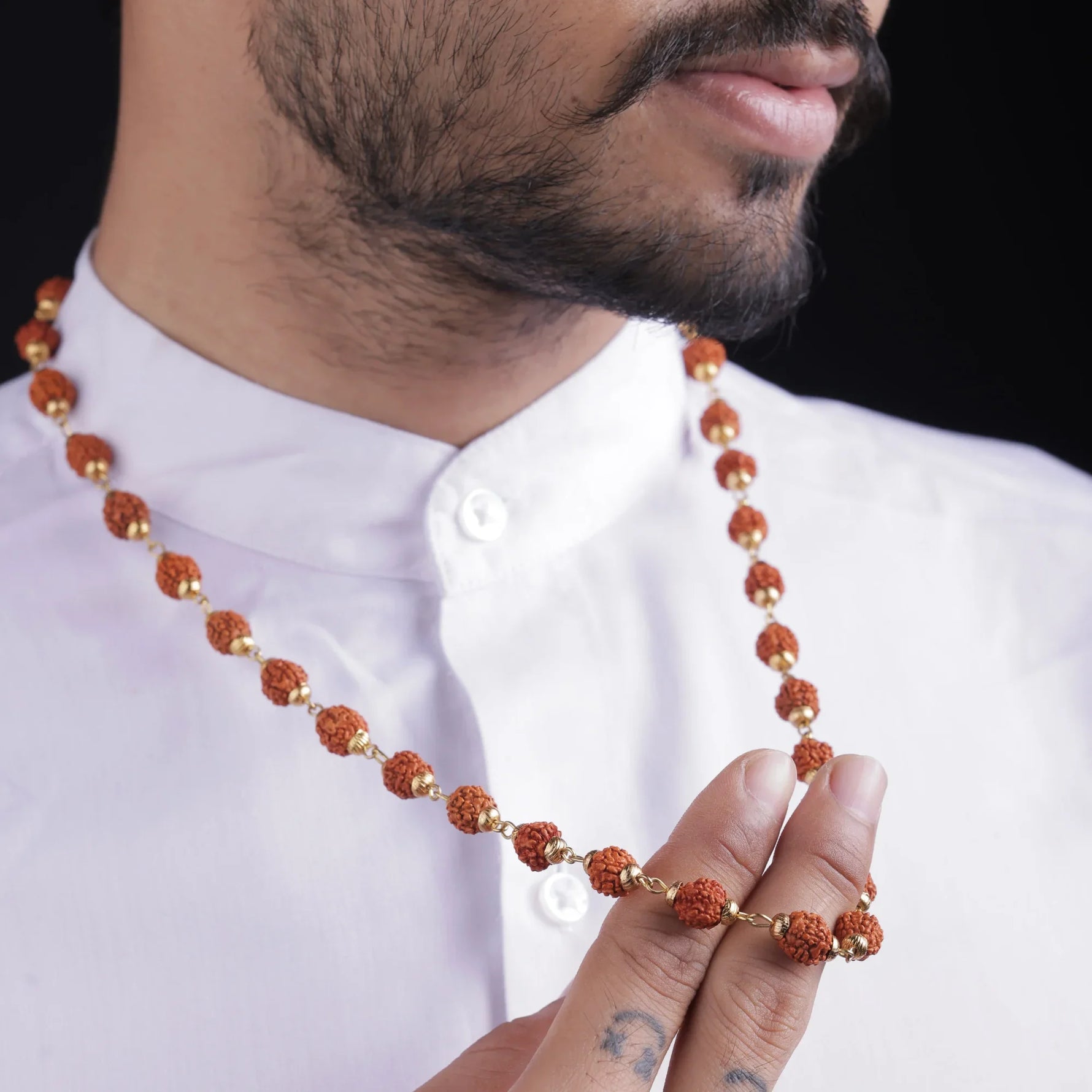 Man wearing a 5 Mukhi Rudraksha mala with gold-tone spacers