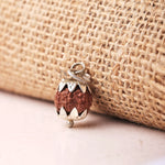 Natural Indonesian Rudraksha pendant beside rustic burlap texture