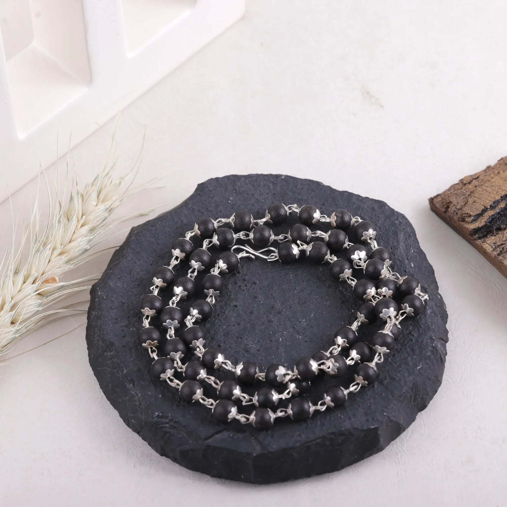 Karungali Malai on black stone display, Divymukhi ebony wood mala