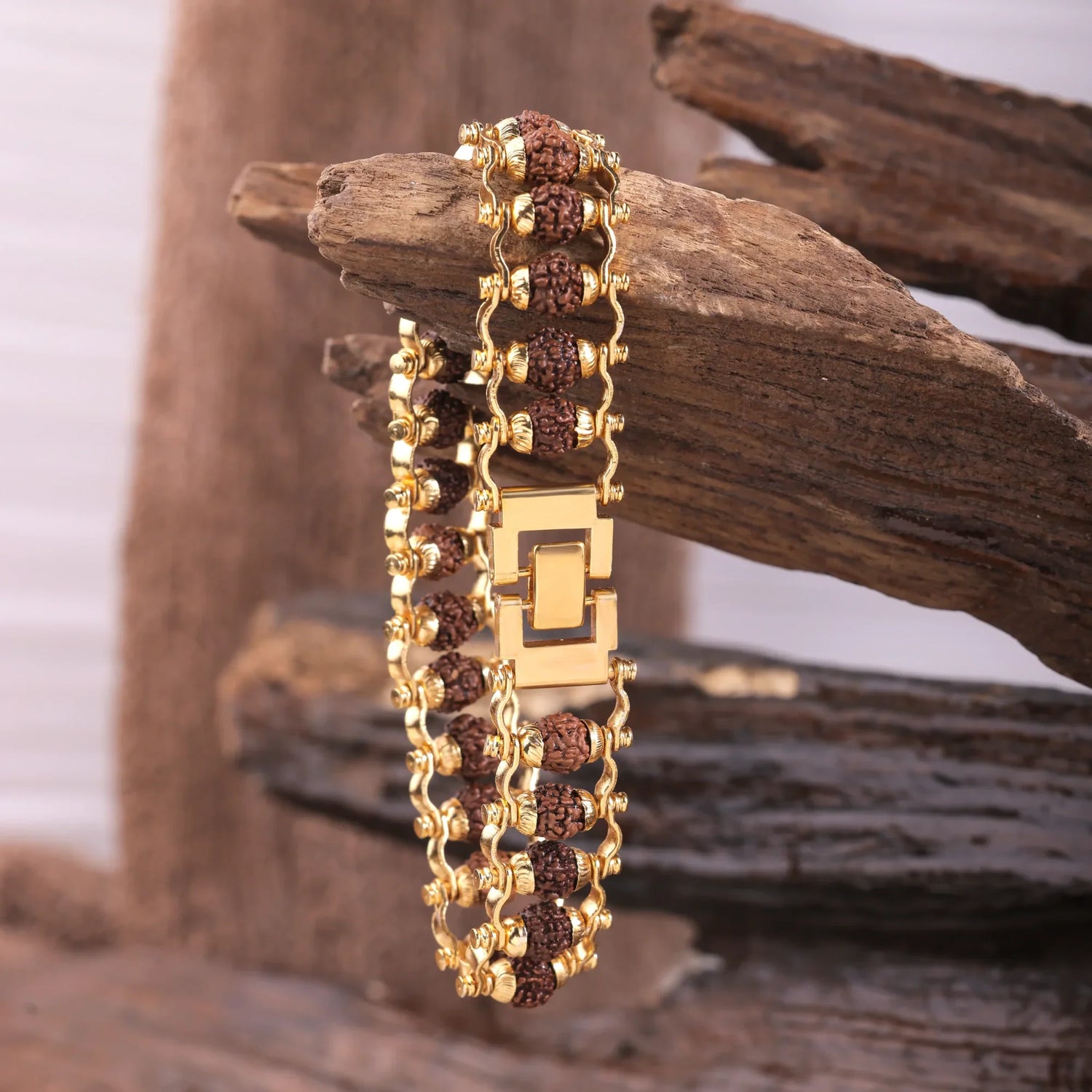 Gold Rudraksha bracelet with gold detailing on wooden background