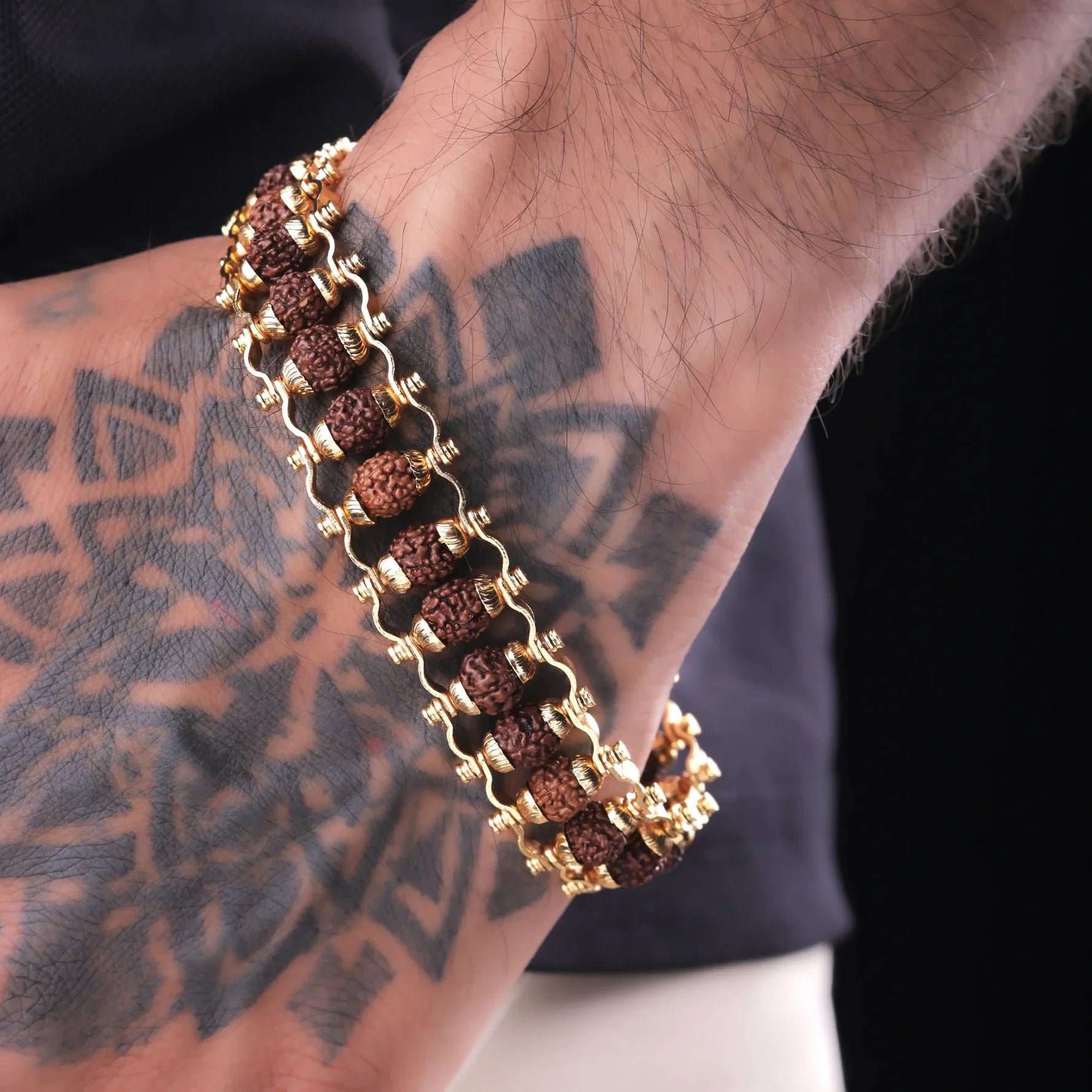 Rudraksha bead bracelet worn on wrist with gold accents