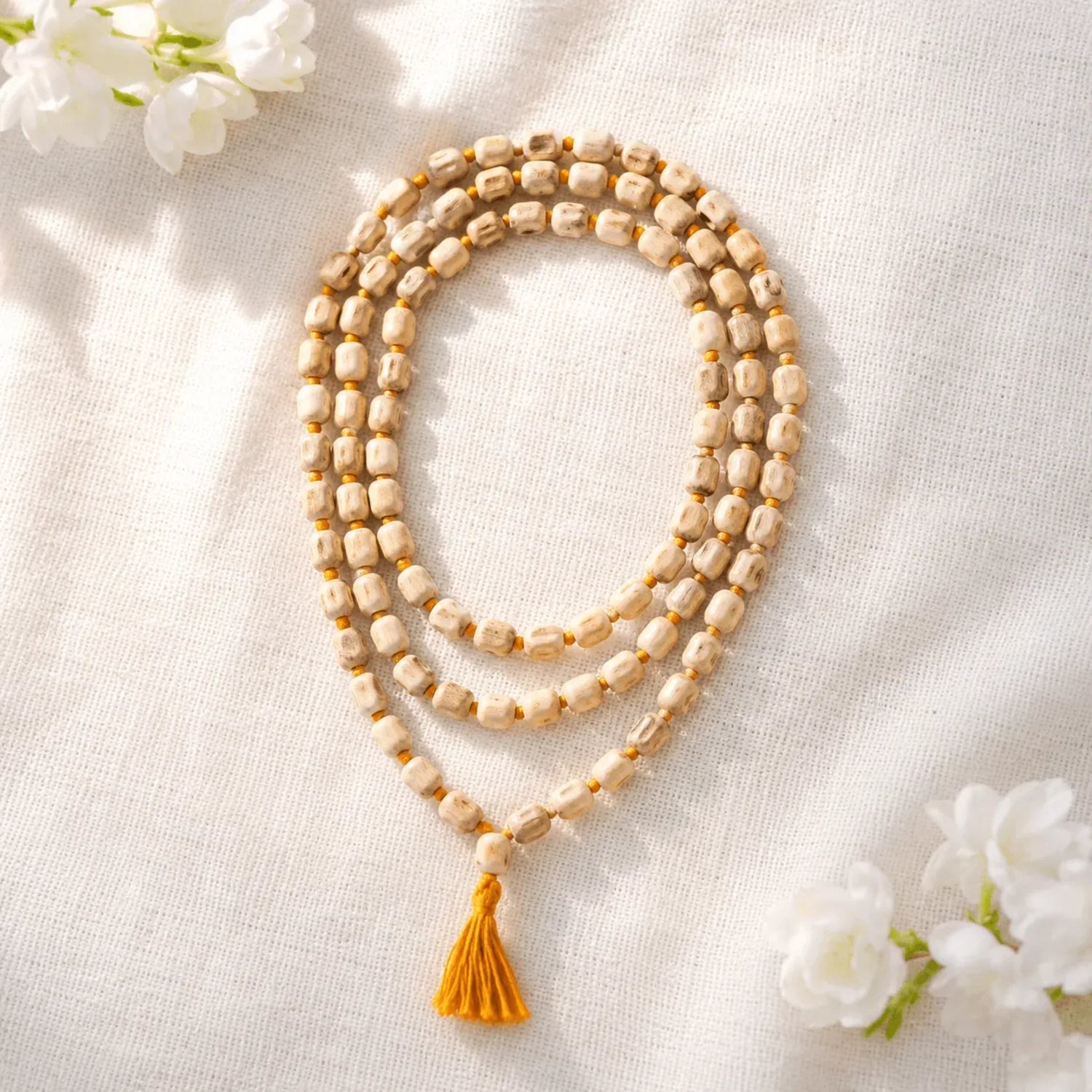Original Tulsi mala, 108 beads with saffron tassel on white fabric
