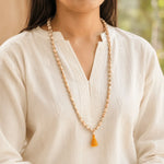 Woman wearing traditional Tulsi japa mala with saffron tassel