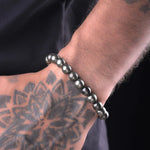 Man wearing natural Pyrite bead bracelet, tattooed wrist